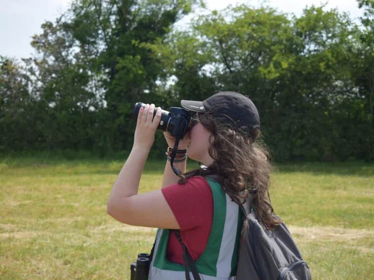 Jeune femme tenant des jumelles à l'aérodrome de Falaise - Monts d'Eraines